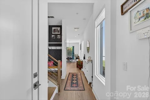 a view of a hallway with wooden floor and windows