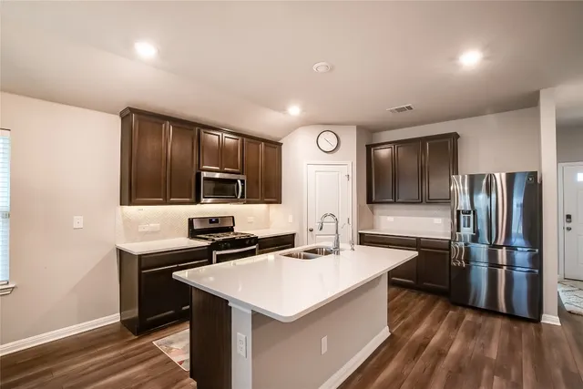a kitchen with a sink stainless steel appliances and cabinets