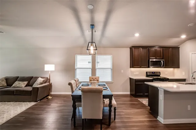 a living room with furniture a chandelier and a flat screen tv