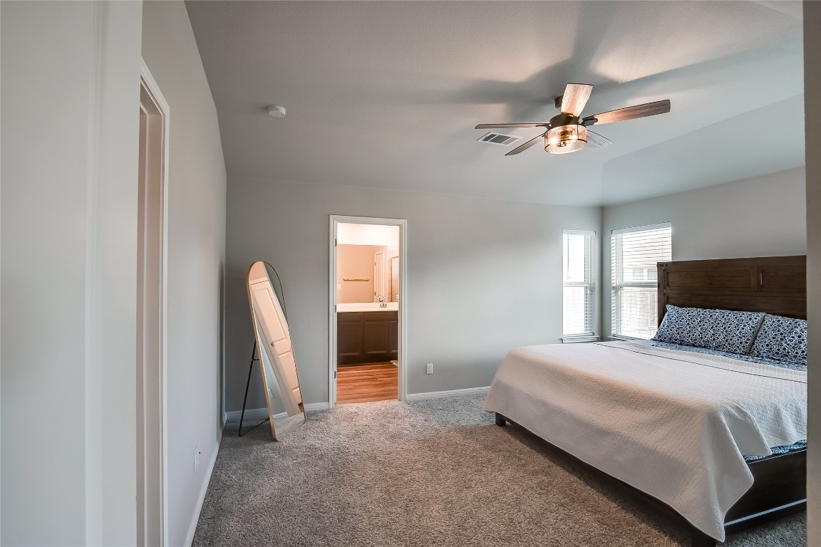 403 Grapefruit Road Hutto, TX 78634 - Photo 16 of 30 a bedroom with a bed and a flat tv screen