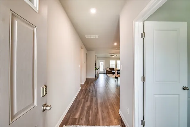 a view of a hallway with wooden floor fireplace and living room