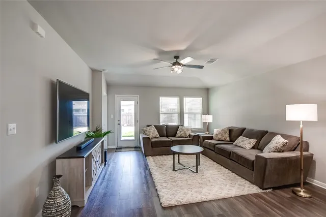 a living room with furniture and wooden floor