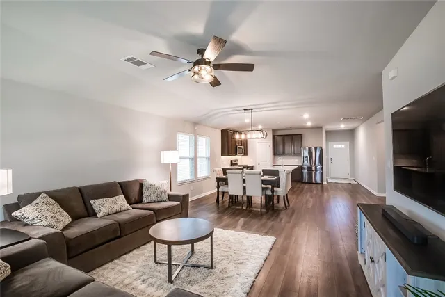 a living room with furniture a rug and a flat screen tv
