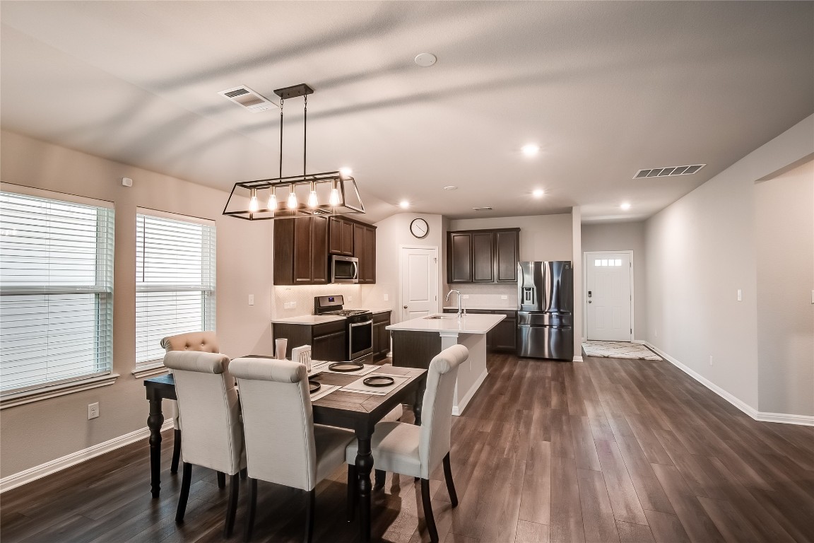 403 Grapefruit Road Hutto, TX 78634 - Photo 10 of 30 a view of a dining room with furniture window and wooden floor