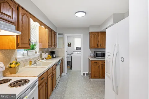 a kitchen with a sink a stove and a refrigerator
