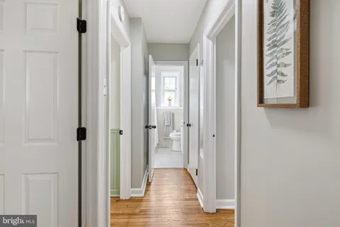 a view of a hallway with wooden floor and closet area