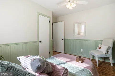 a bedroom with a bed and a chandelier fan