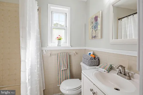 a bathroom with a sink vanity mirror and toilet