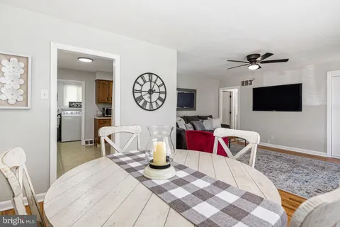a living room with furniture a flat screen tv and a wall painting