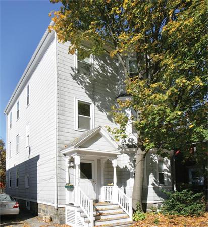 a front view of a house with a tree