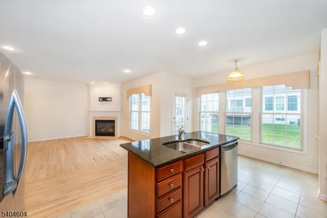 a large white kitchen with granite countertop a sink and a stove