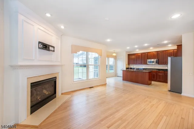 a large kitchen with stainless steel appliances a large window and a fireplace