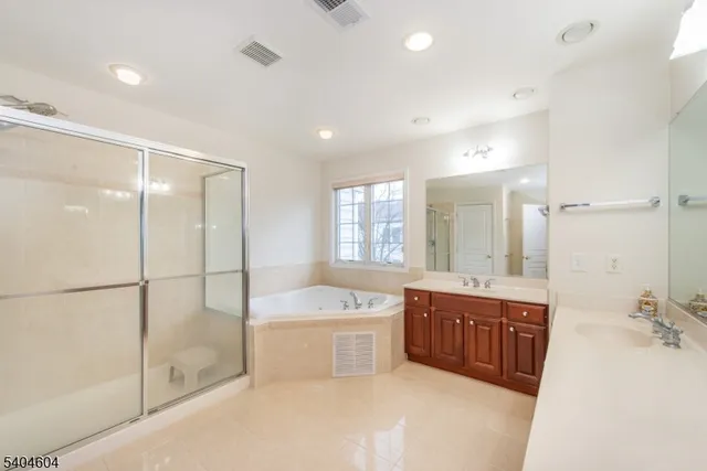 a bathroom with a tub sink shower and mirror