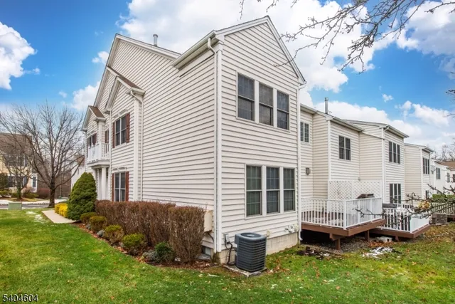 a view of a house with a backyard and chairs
