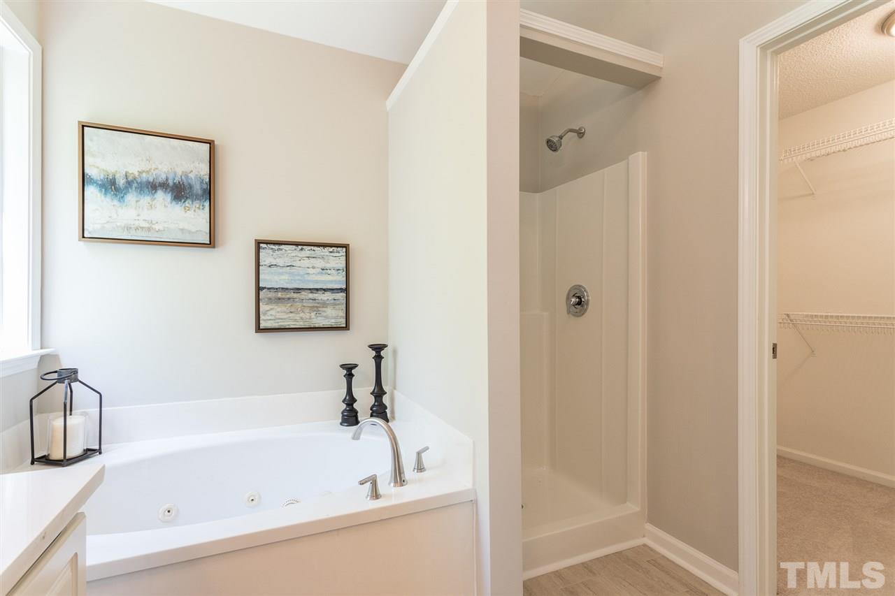 4628 Drewbridge Way Raleigh, NC 27604 - Photo 17 of 21 a white bath tub sitting next to a bathroom sink