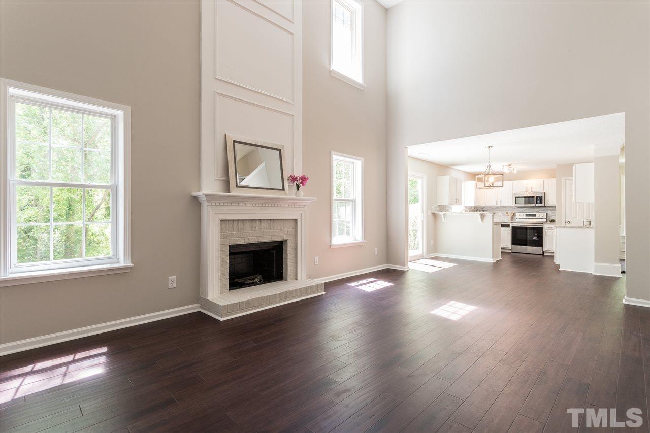 4628 Drewbridge Way Raleigh, NC 27604 - Photo 3 of 21 an empty room with wooden floor fireplace and windows