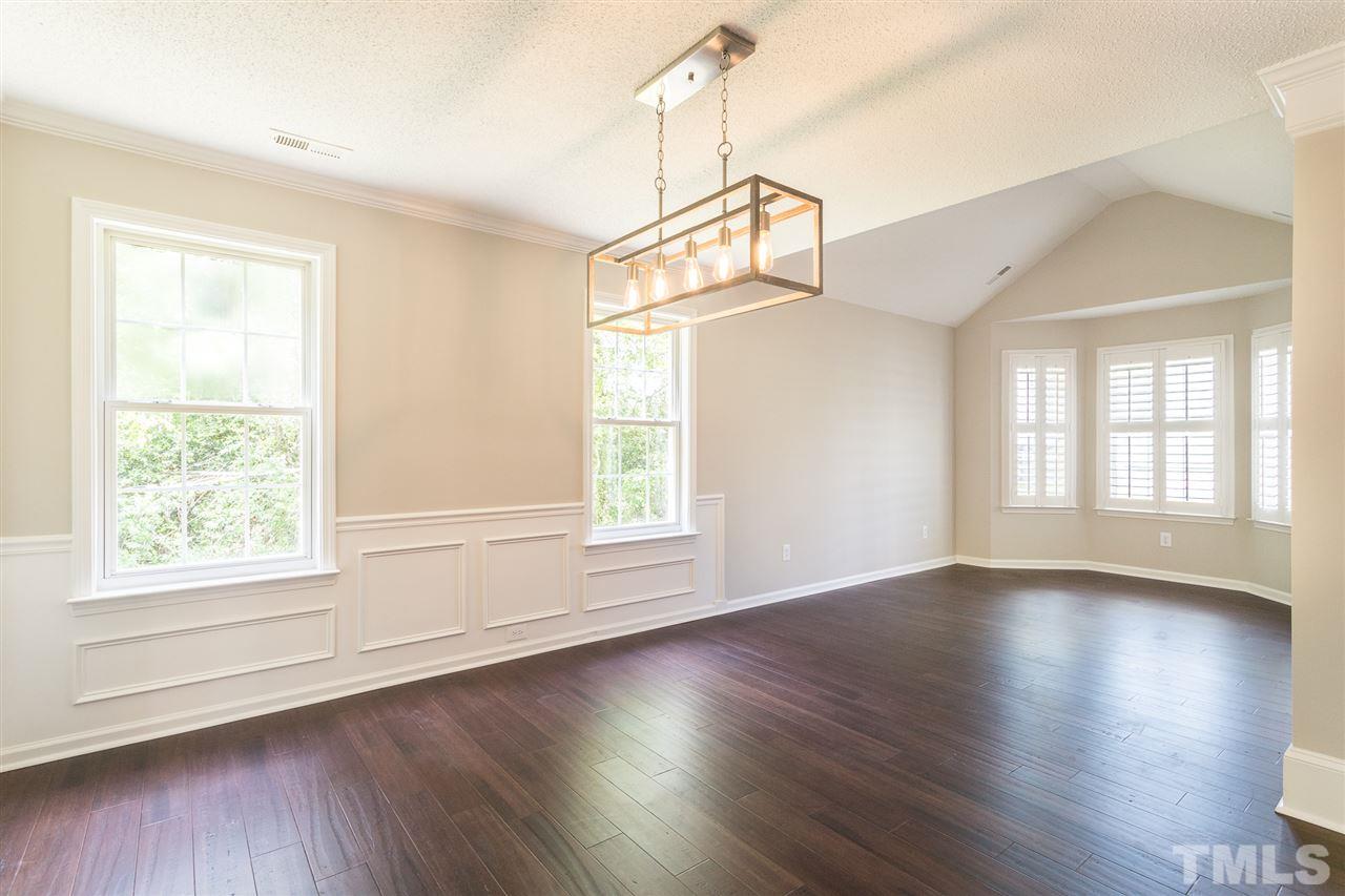 4628 Drewbridge Way Raleigh, NC 27604 - Photo 4 of 21 an empty room with wooden floor and windows