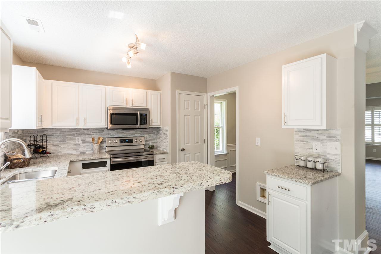 4628 Drewbridge Way Raleigh, NC 27604 - Photo 8 of 21 a kitchen with stainless steel appliances kitchen island granite countertop a stove sink and microwave
