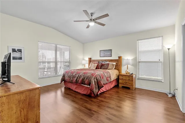 a spacious bedroom with a bed and wooden floor
