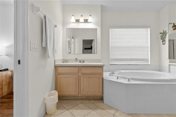 a bathroom with a sink a large mirror and a bathtub