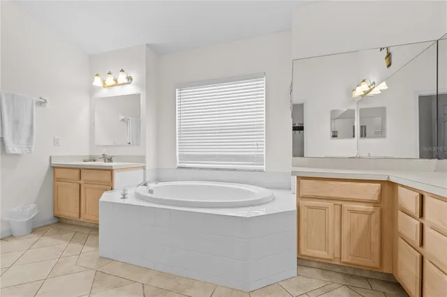 a bathroom with a bathtub sink and mirror