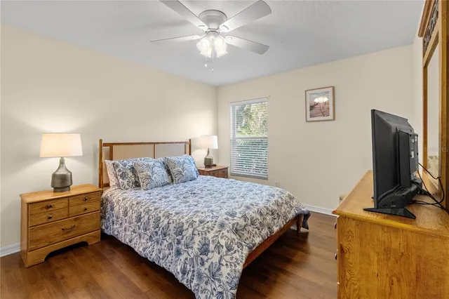 a bedroom with a bed and a flat tv screen on a dresser