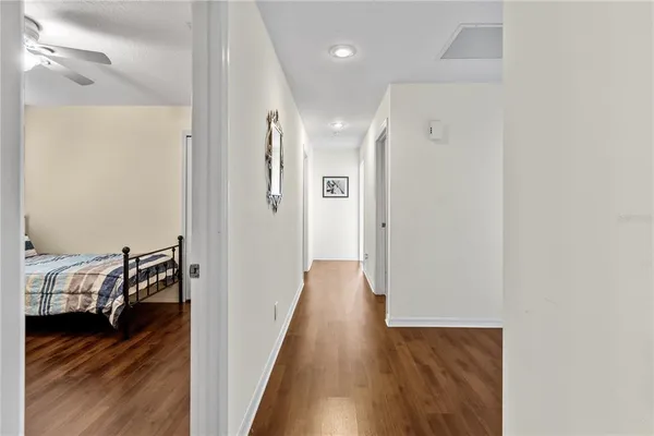 a view of a hallway with wooden floor and bedroom