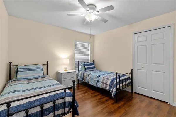 a bedroom with two beds a chandelier and a window