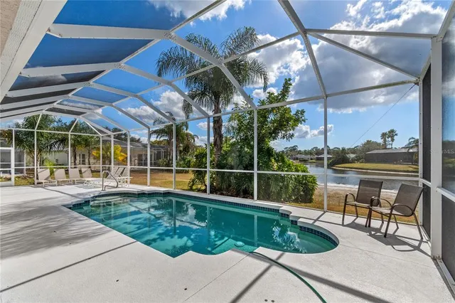 a view of a swimming pool with a patio and dining table