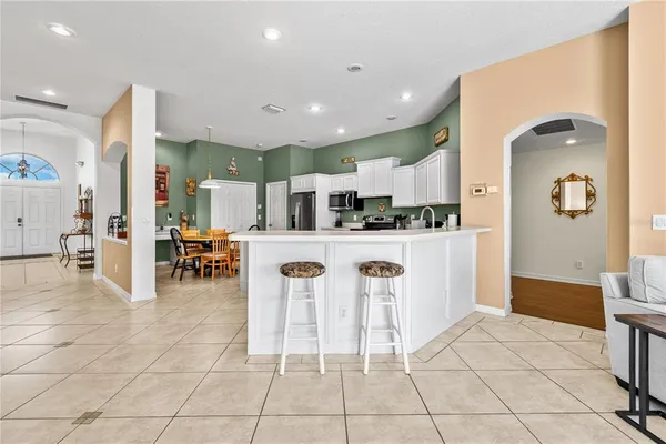 a kitchen with stainless steel appliances kitchen island granite countertop a refrigerator and a sink