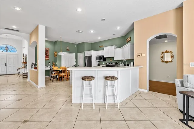 a kitchen with stainless steel appliances kitchen island granite countertop a refrigerator and a sink
