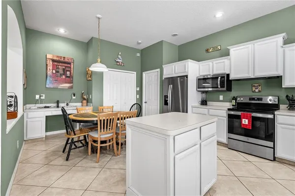 a kitchen with a dining table chairs and refrigerator