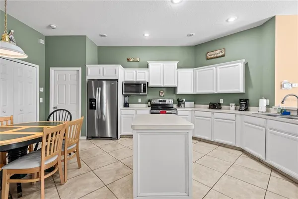 a kitchen with refrigerator cabinets and chairs