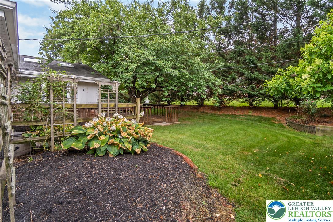 1328 Russett Road Allentown, PA 18104 - Photo 39 of 46 A well-maintained yard offers a wooden deck and rich landscaping.