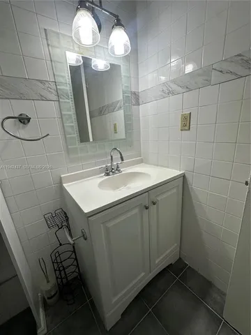 a bathroom with a sink a light fixture and a mirror