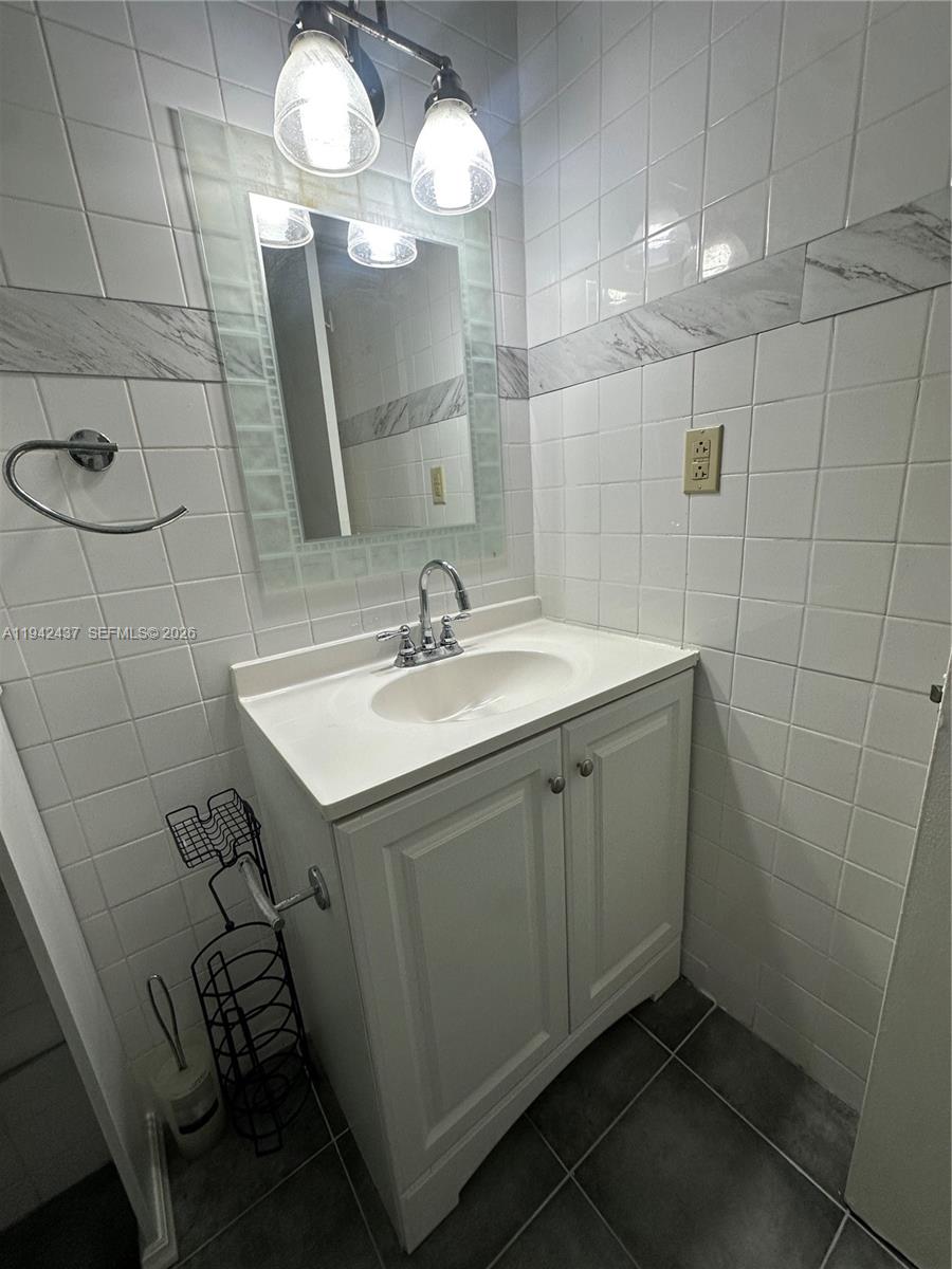 8605 Southwest 68th Court, Unit 26 Pinecrest, FL 33156 - Photo 11 of 21 a bathroom with a sink a light fixture and a mirror
