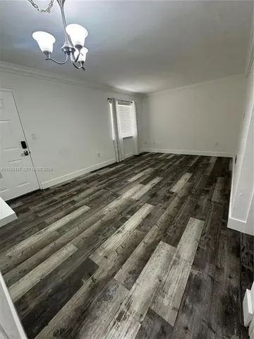 a view of a room with wooden floor and ceiling fan