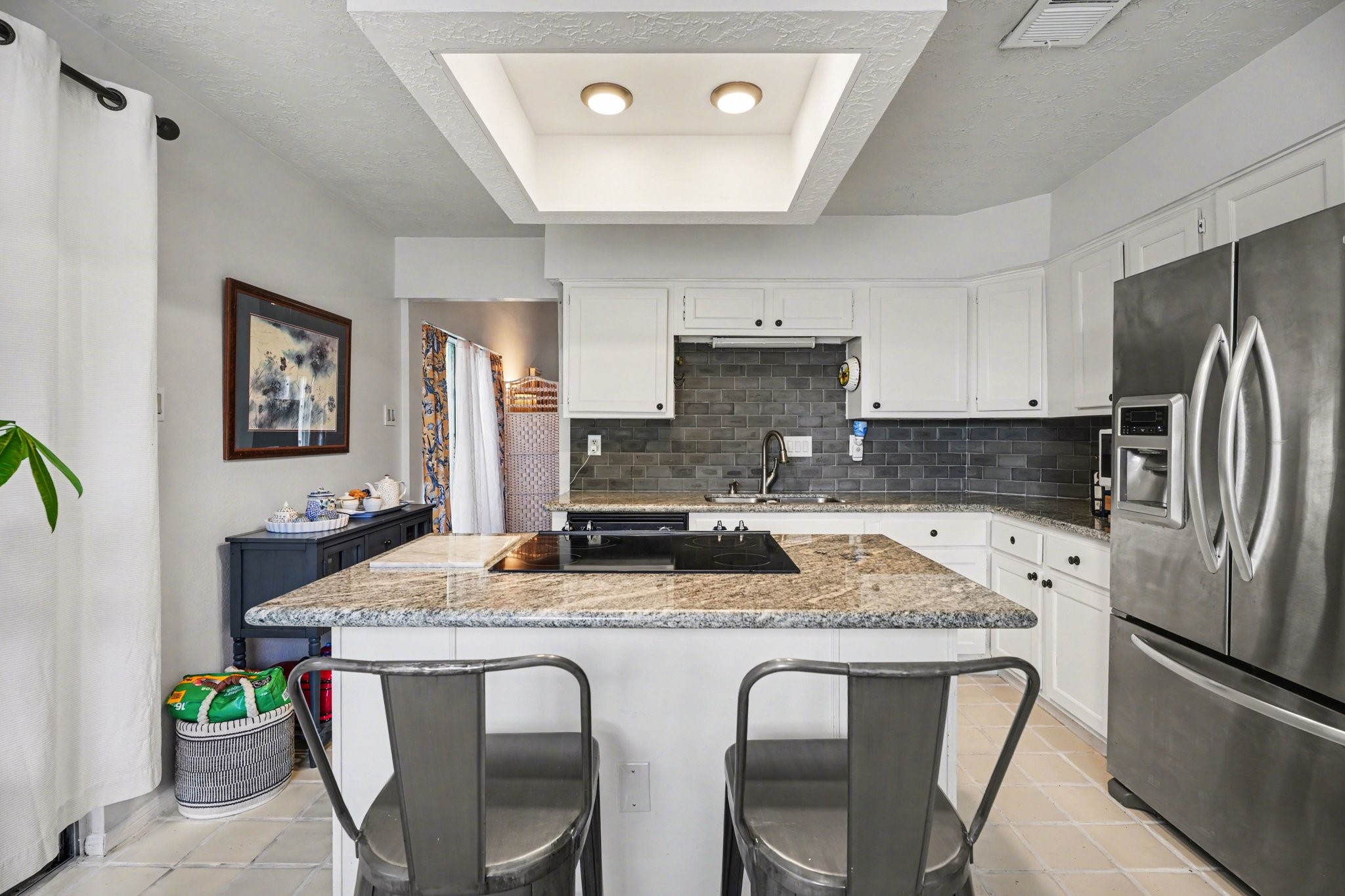 16810 Finewood Way Houston, TX 77058 - Photo 13 of 23 Beautiful tile backsplash and granite countertops, complemented by a stainless steel sink and island cooktop.