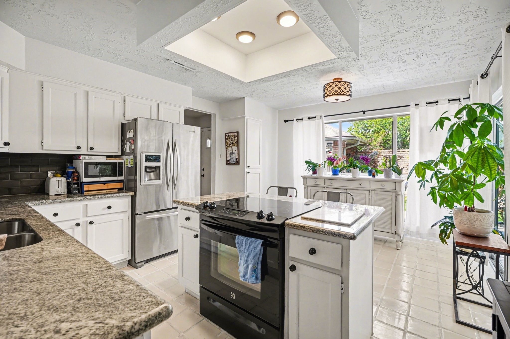 16810 Finewood Way Houston, TX 77058 - Photo 14 of 23 Kitchen filled with natural light from abundant windows and sliding glass door—truly a plant lover’s dream.