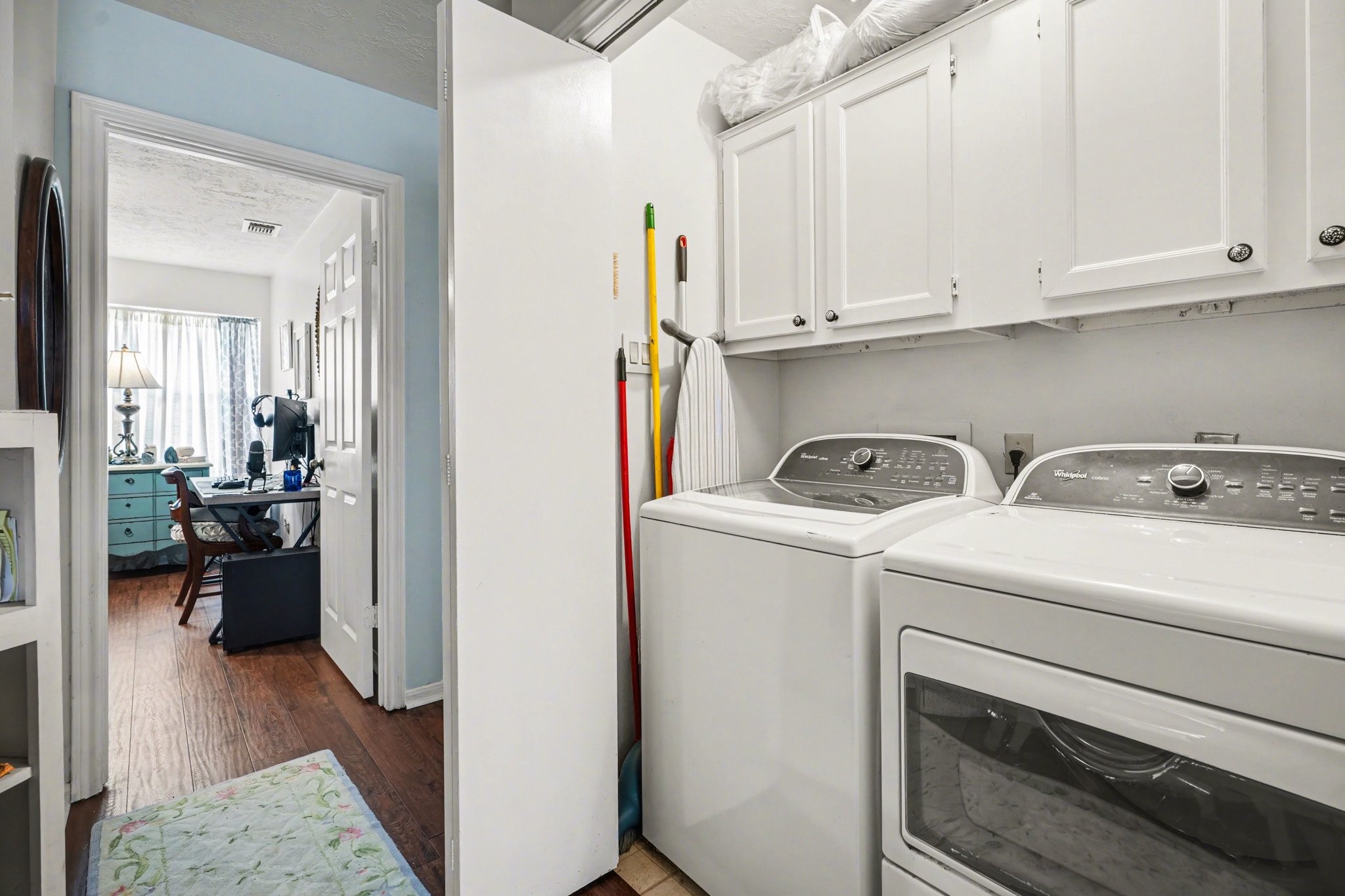 16810 Finewood Way Houston, TX 77058 - Photo 21 of 23 Conveniently located between the bedrooms, the hallway utility room includes a washer and dryer with cabinetry above for added storage.