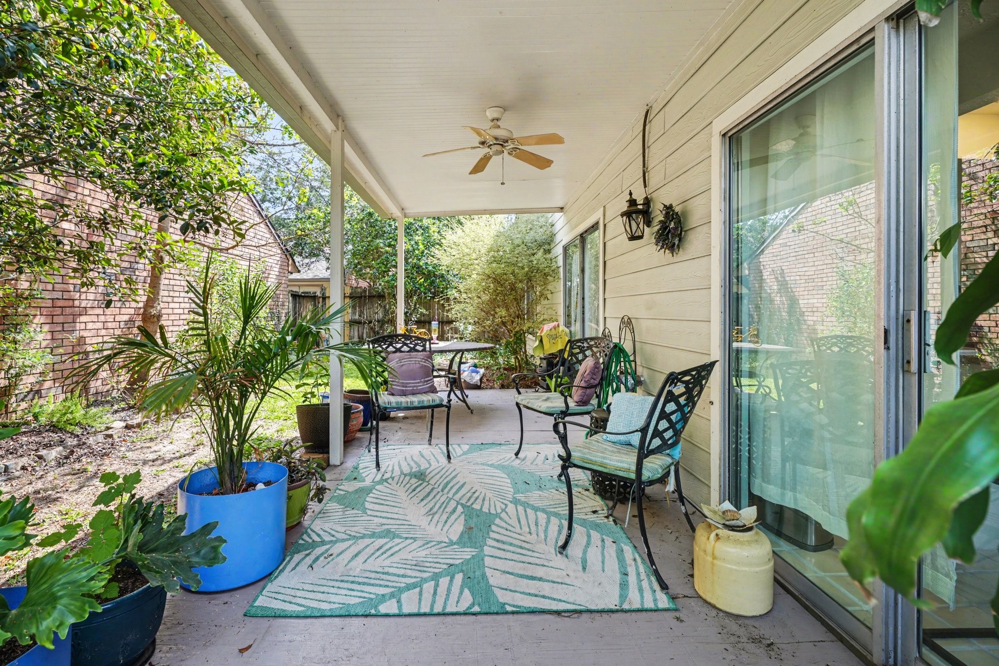 16810 Finewood Way Houston, TX 77058 - Photo 22 of 23 Expansive back patio surrounded by lush greenery—perfect for bird watching or enjoying the outdoors with friends and family.