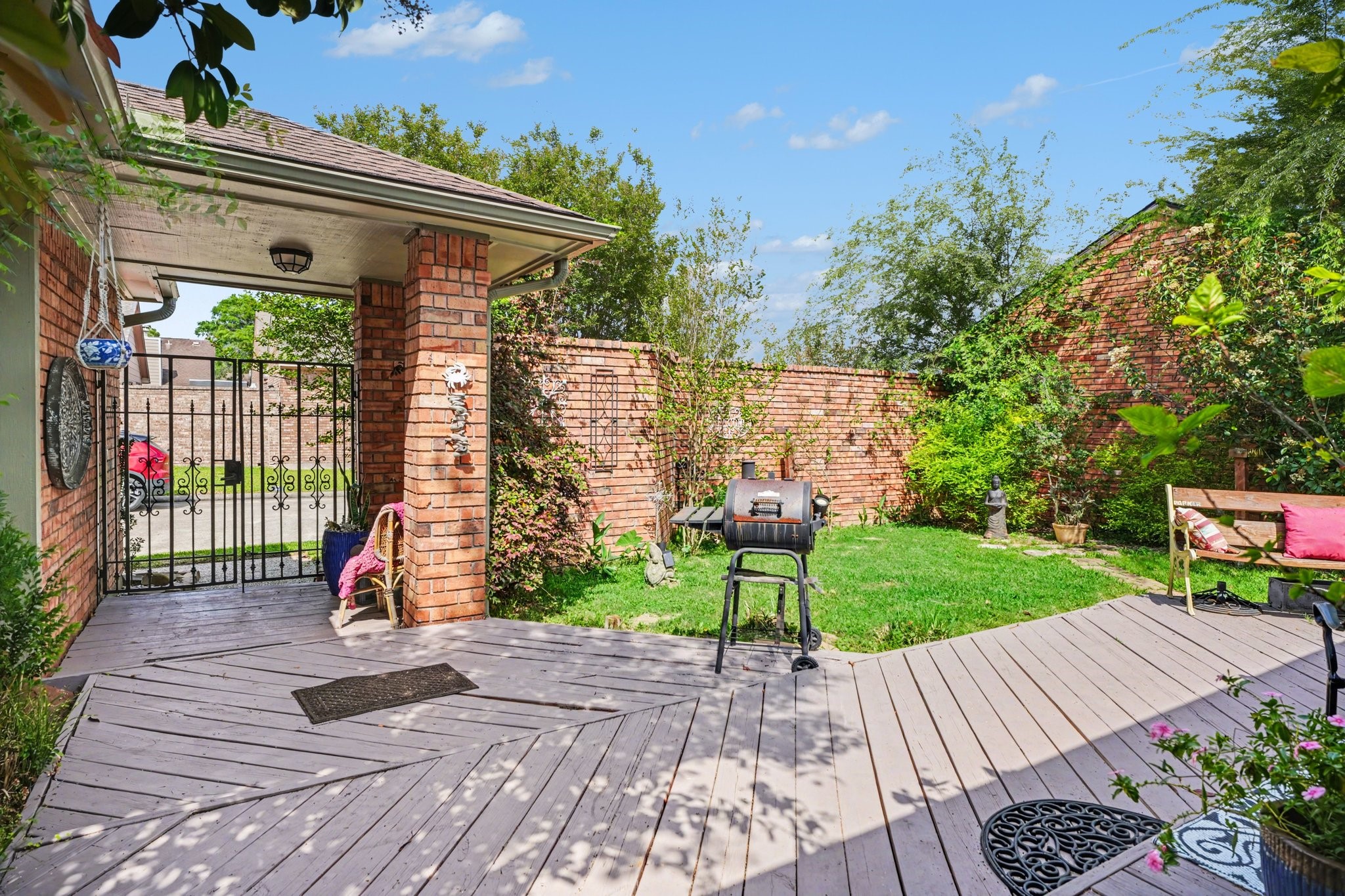 16810 Finewood Way Houston, TX 77058 - Photo 4 of 23 Expansive multi-level patio with fresh paint and green space—perfect for entertaining or BBQs—enclosed by a private brick fence.
