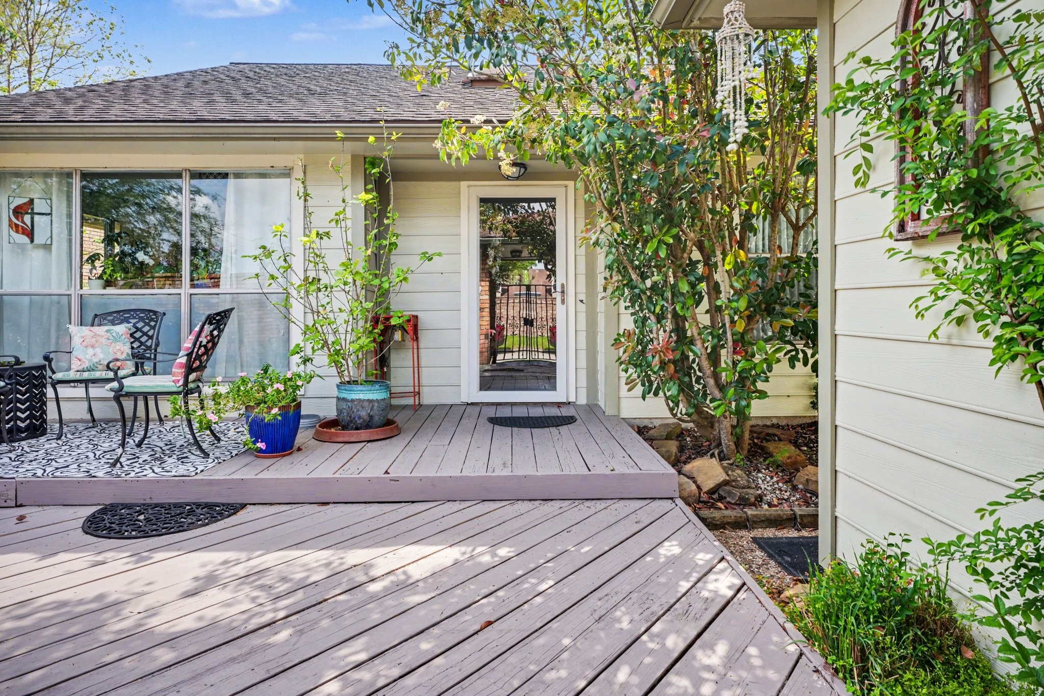 16810 Finewood Way Houston, TX 77058 - Photo 5 of 23 Lush, welcoming entry with a private patio—ideal for enjoying your morning coffee—featuring a glass screen door.
