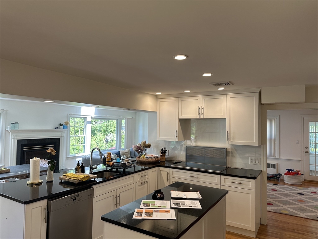 45 Wellesley Road Belmont, MA 02478 - Photo 10 of 42 a kitchen with a stove a sink a refrigerator and blue cabinets with wooden floor