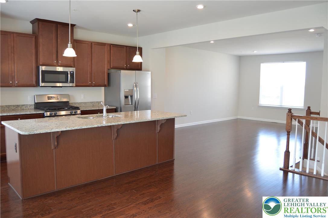 2332 Raya Way Easton, PA 18045 - Photo 7 of 14 a kitchen with stainless steel appliances granite countertop a refrigerator a sink dishwasher a stove and a oven with wooden floor