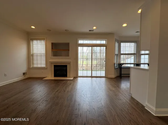 an empty room with wooden floor and a fireplace