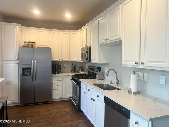 a kitchen with stainless steel appliances granite countertop a refrigerator sink and cabinets