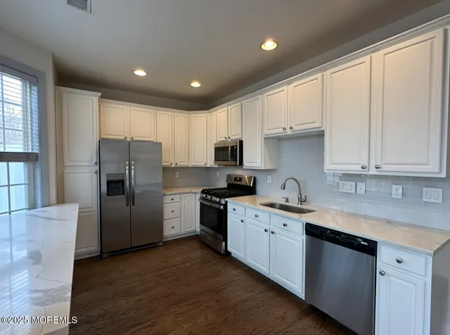 a kitchen with stainless steel appliances granite countertop a refrigerator sink and cabinets