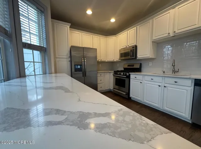 a kitchen with stainless steel appliances granite countertop a refrigerator sink and cabinets