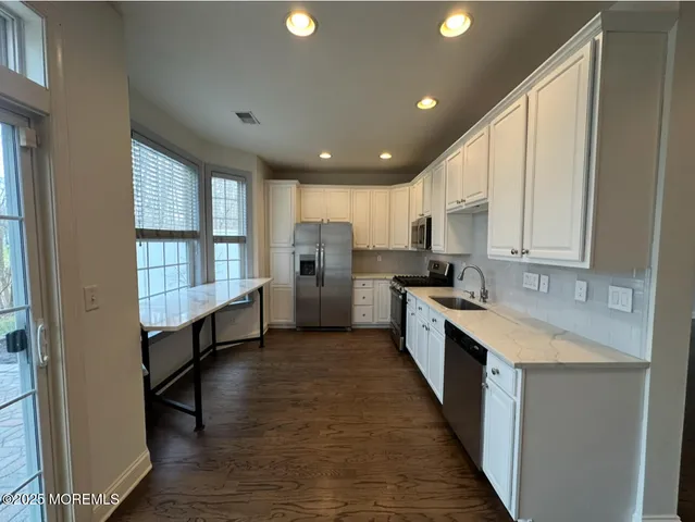 a kitchen with stainless steel appliances granite countertop a stove a sink and a refrigerator